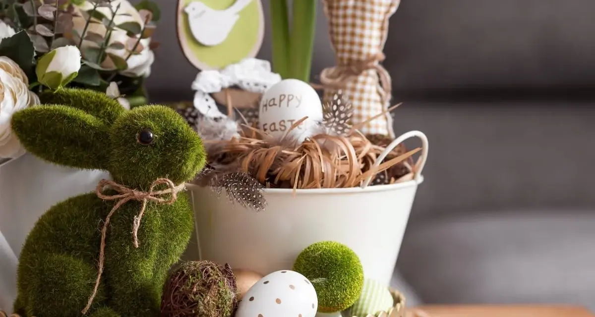 Zielony, mchowy zajączek i pisanki tworzą najpiękniejsze dekoracje wielkanocne. W koszyku jajko z napisem "Happy Easter".