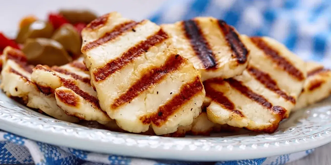 Grillowany ser halloumi na talerzu, z widocznymi paskami z grilla. Idealny dodatek do sałatek, z niską zawartością halloumi kcal.
