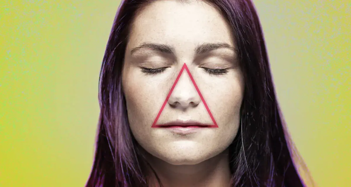 Frauenkopf mit geschlossenen Augen, auf dessen Nase und Mund ein rotes Dreieck liegt. Ein Pickel im Todesdreieck im Gesicht kann gefährlich sein.