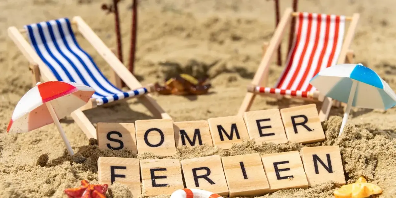 Strandkörbchen, Palmen und die Worte "Sommerferien" im Sand. Perfekt für die Sommerferien in Brandenburg!