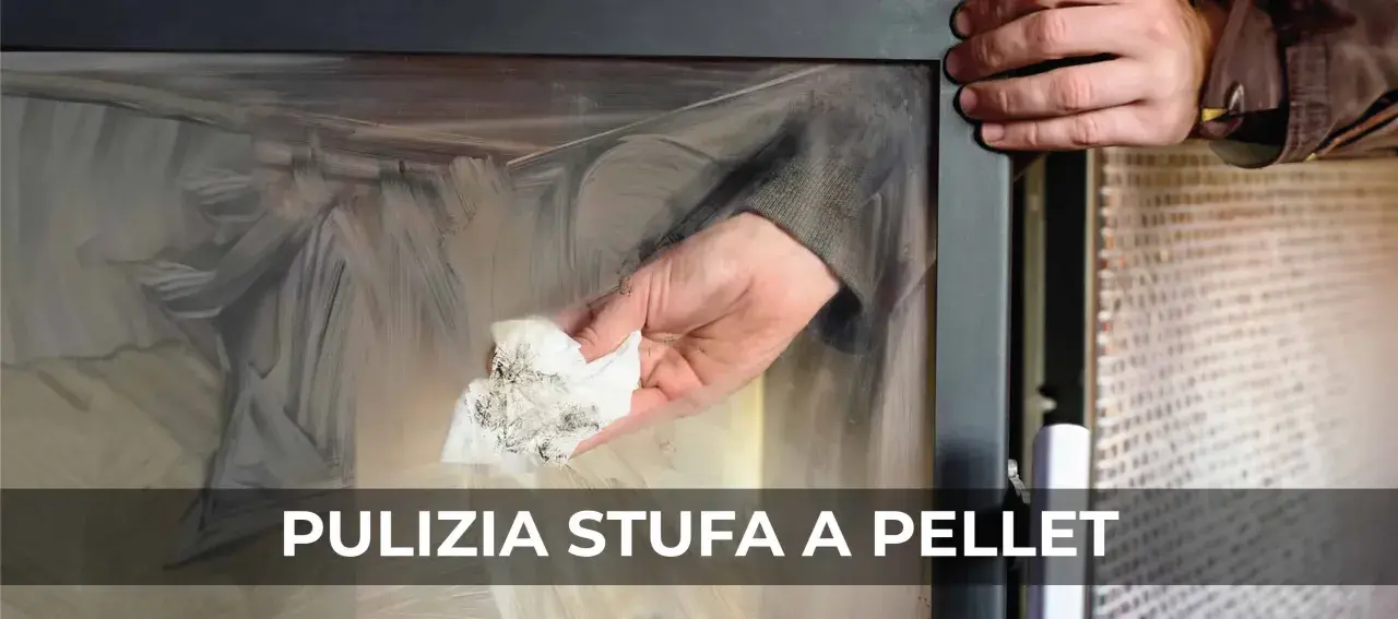 Mano che pulisce il vetro di una stufa a pellet con un panno sporco di fuliggine.