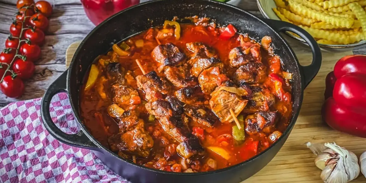 Herzhaftes Schaschlik-Rezept in Gusseisenpfanne mit Paprika, Zwiebeln und Tomaten. Dazu Pommes und frische Zutaten.