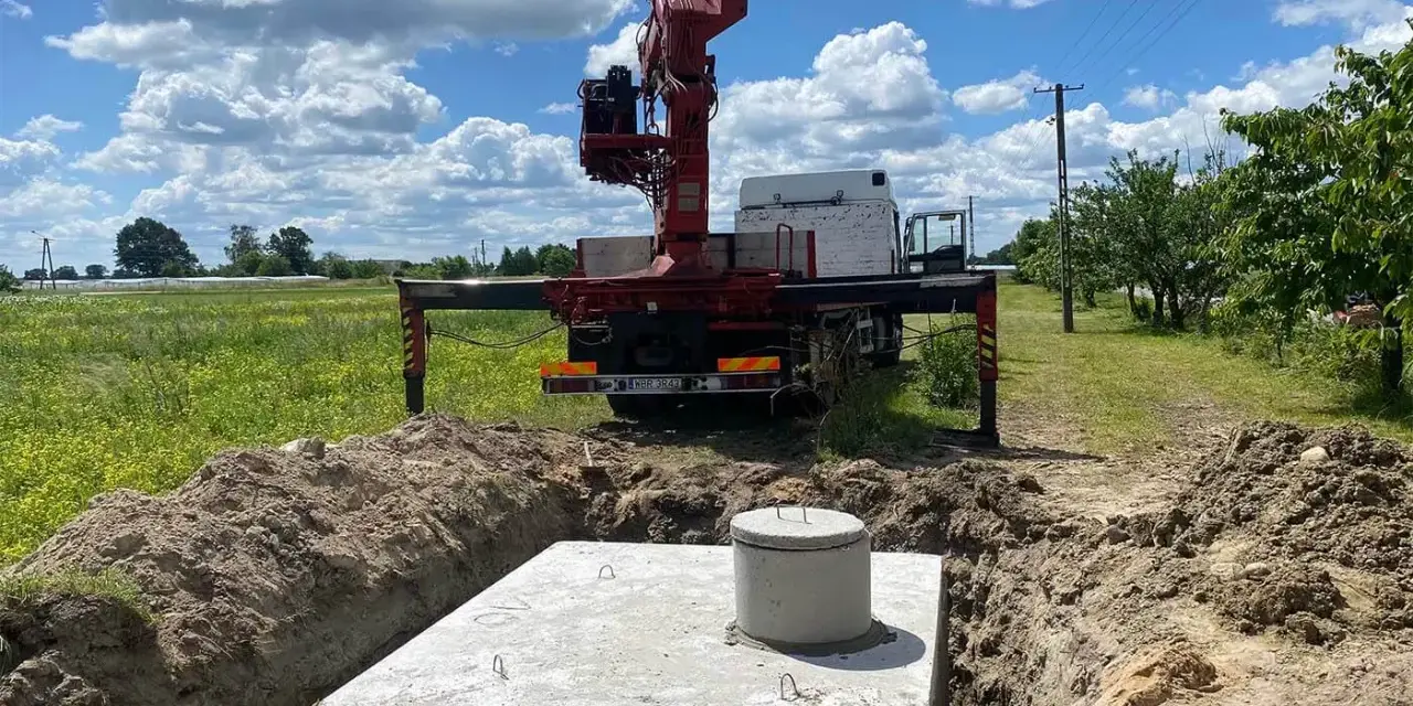 Montaż szamba betonowego w wykopie. Dostępne różne rodzaje szamb, ten jest w trakcie instalacji.