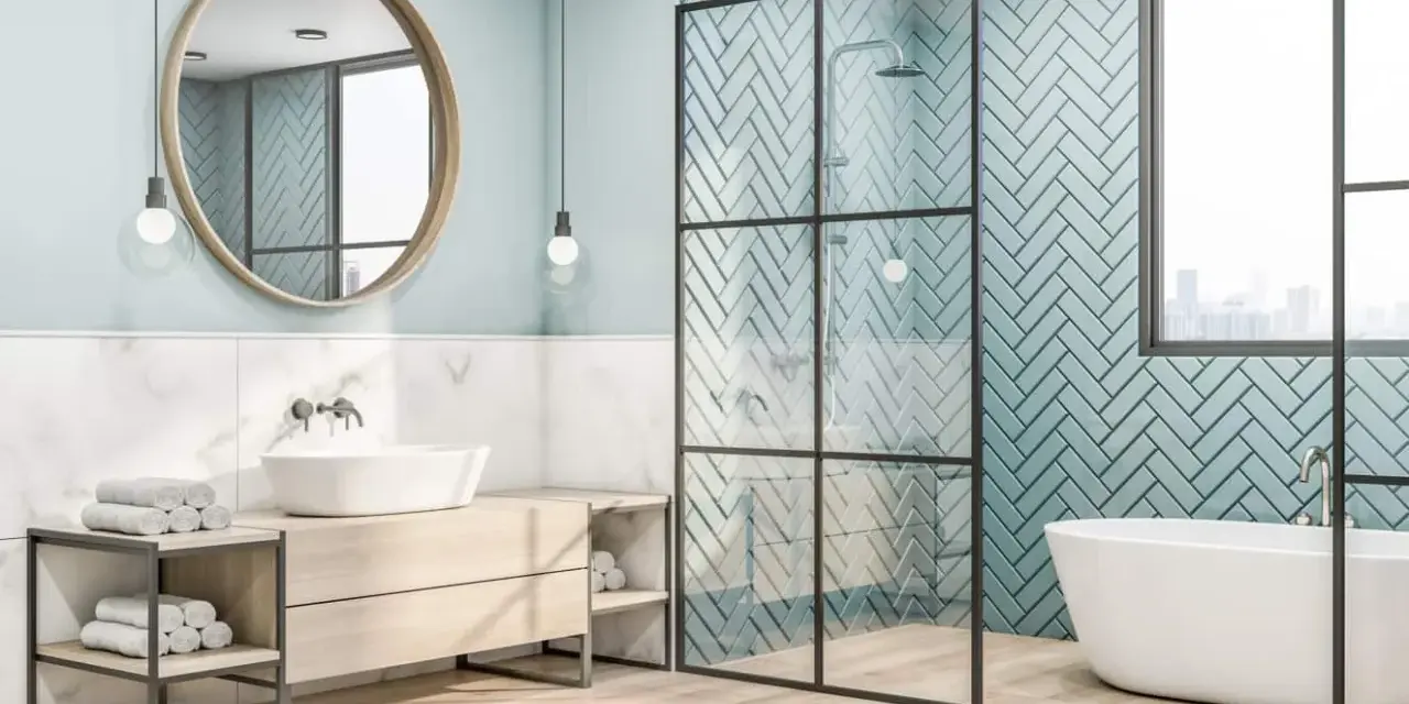 Salle de bain moderne avec baignoire îlot et douche vitrée. Le mur de la douche est orné d'un magnifique type de carrelage bleu clair en chevrons.
