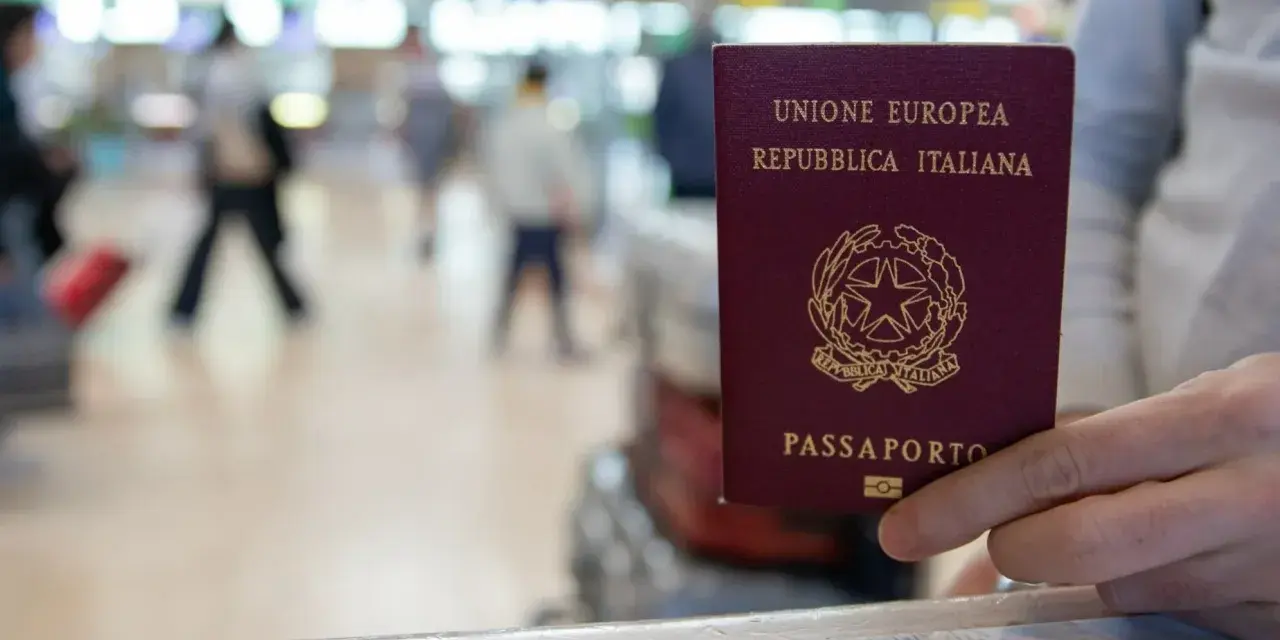 W podróży na Wyspy Kanaryjskie, czy na wyspy kanaryjskie potrzebny jest paszport? W ręku włoski paszport, na tle lotniska.