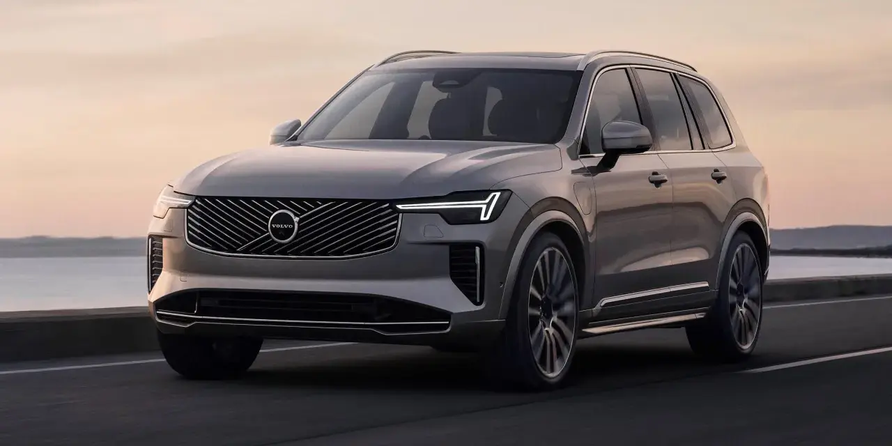 Elegancki, szary Volvo XC90 T8 sunie po drodze przy zachodzie słońca.