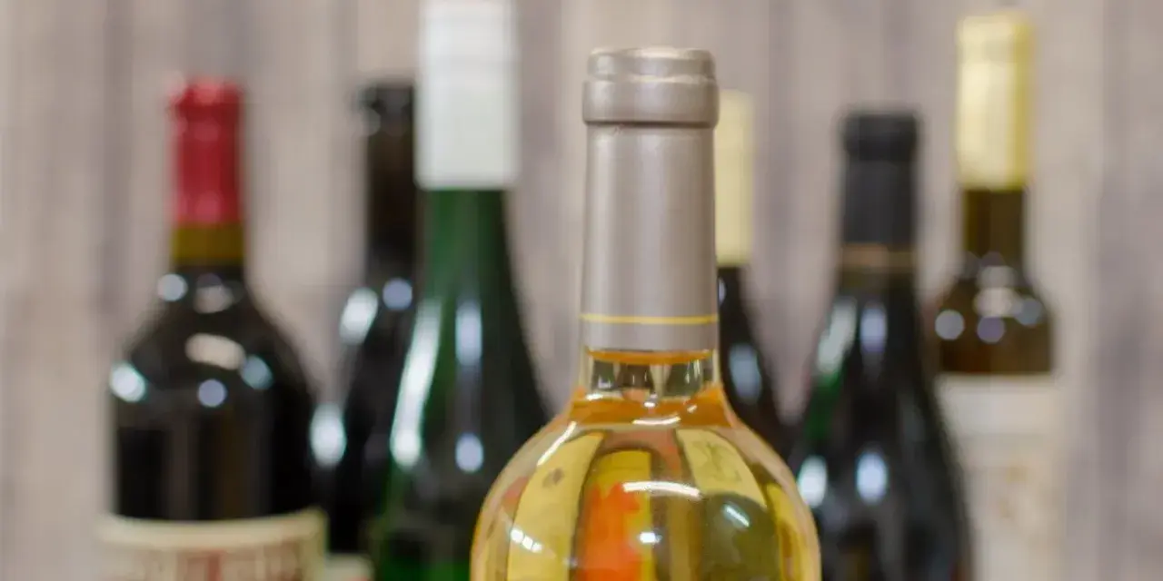 Butelki z winem na tle drewnianej ściany. Zastanawiasz się, ile alkoholu można wziąć do Norwegii samolotem?