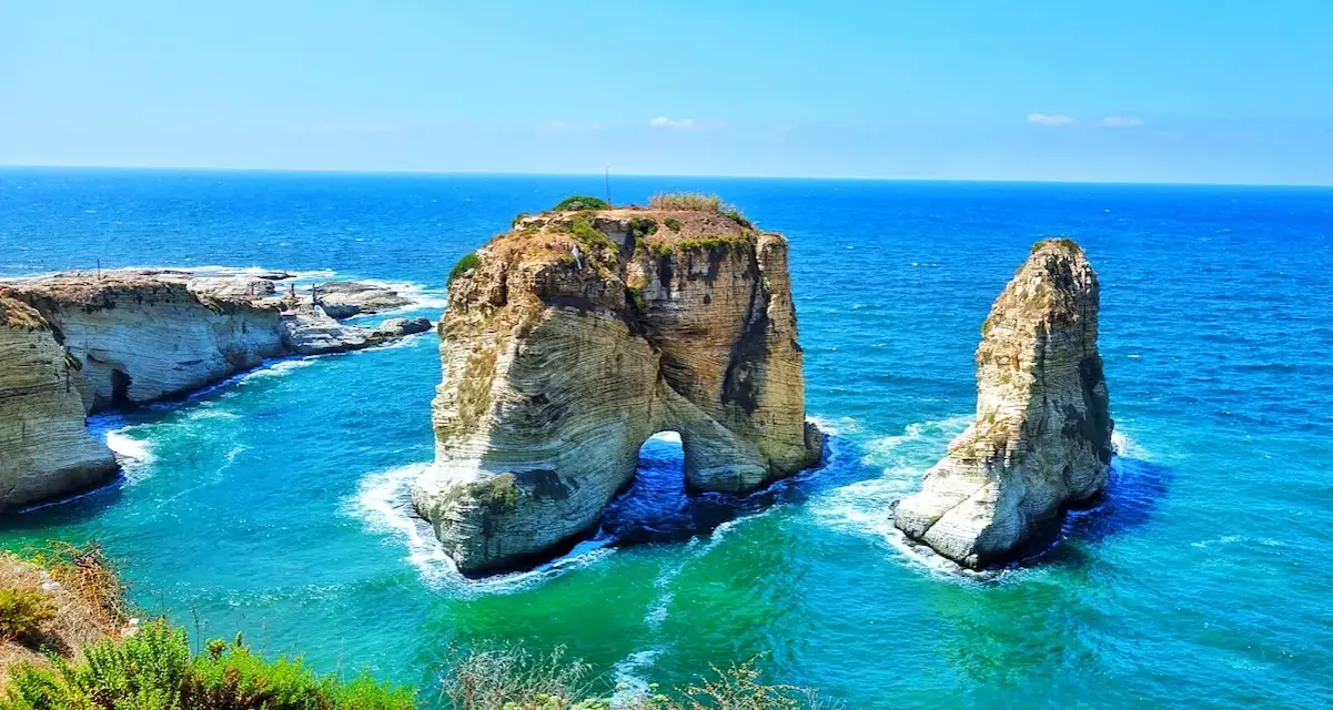The Raouché sea stacks, iconic natural landmarks and historical sites in Lebanon, stand majestically against the bright blue Mediterranean Sea.