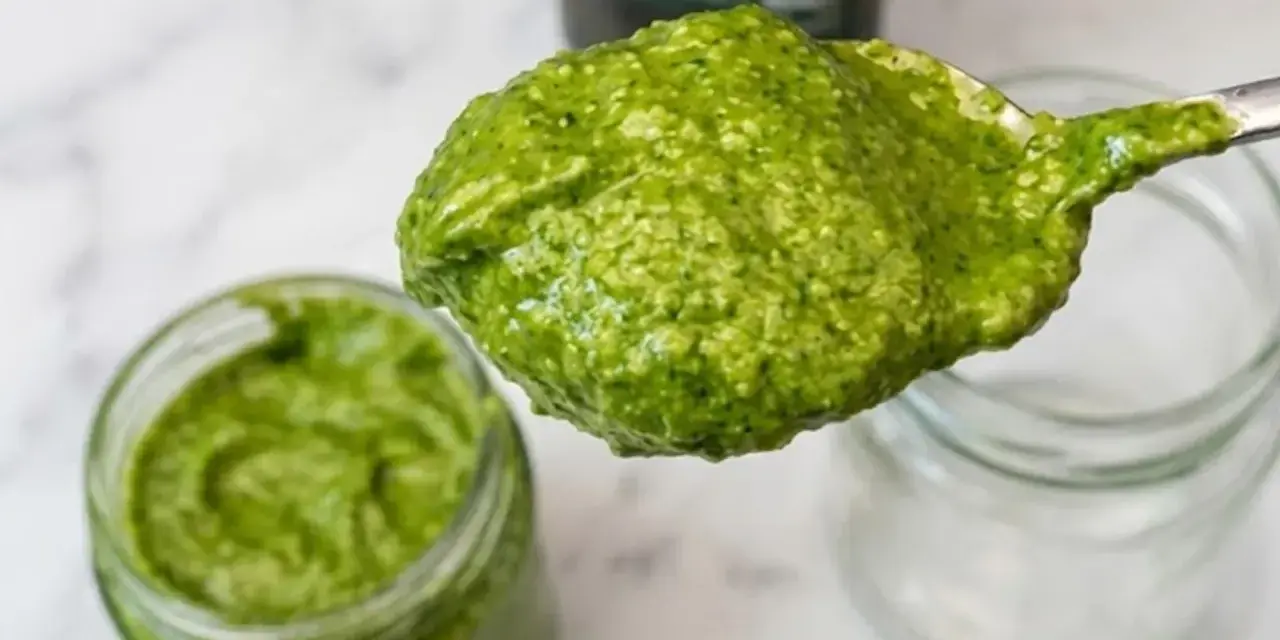 Un cucchiaio di fresco pesto genovese, pronto per essere messo in un vasetto. La ricetta pesto genovese frullatore è facile e veloce.