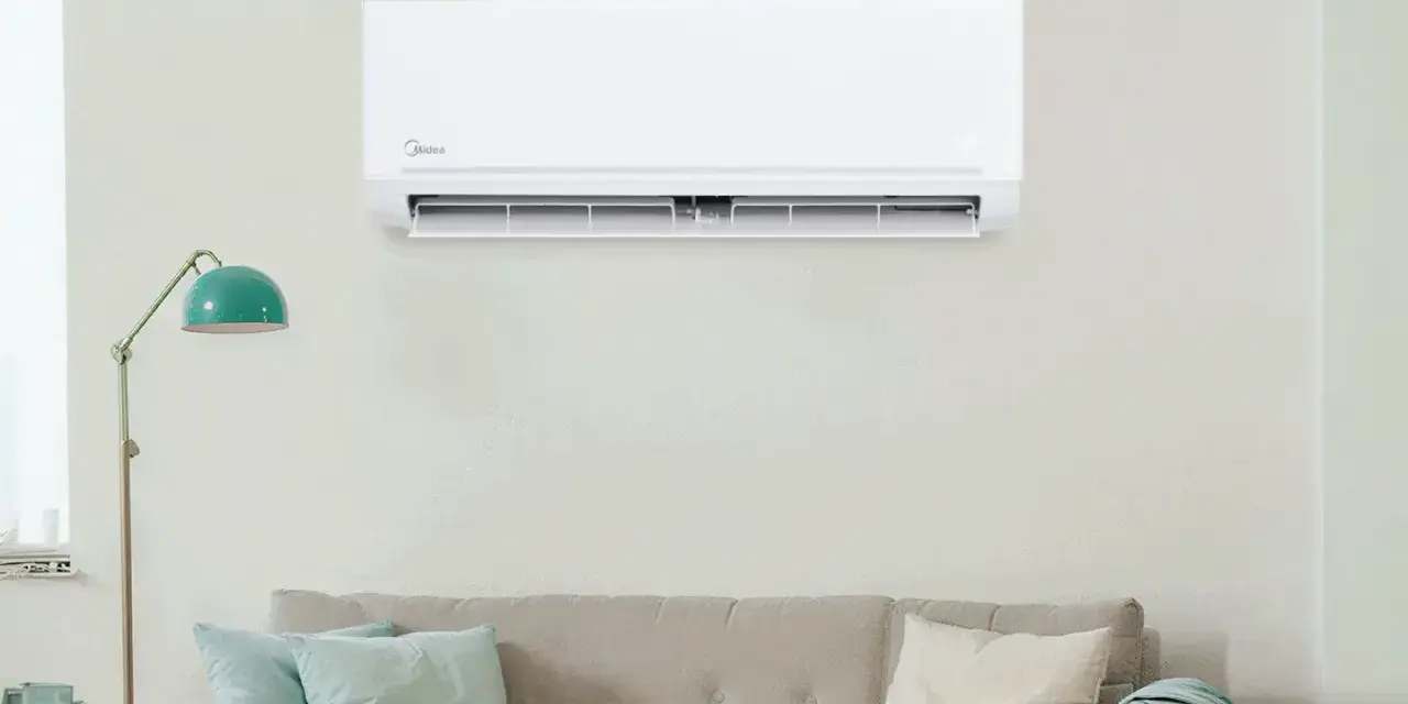 Un aire acondicionado Midea instalado en una pared sobre un sofá. Guía visual para como instalar un aire acondicionado.