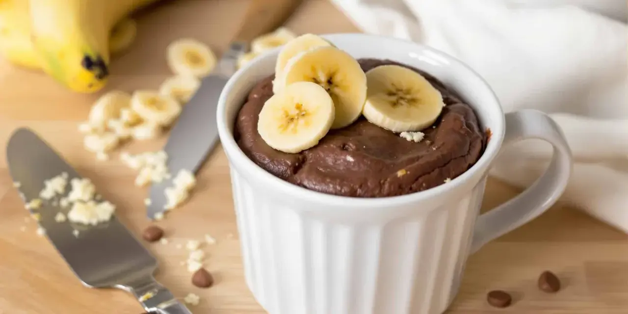 Un délicieux mug cake banane au chocolat, garni de rondelles de banane fraîche. Parfait pour une envie gourmande rapide.