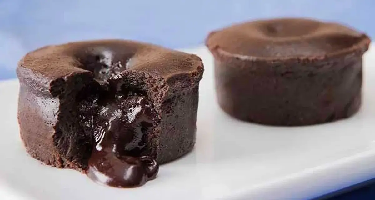 Fondant au chocolat coulant, une gourmandise inspirée de la recette de Cyril Lignac. Le cœur liquide de chocolat fond sur la plaque blanche.