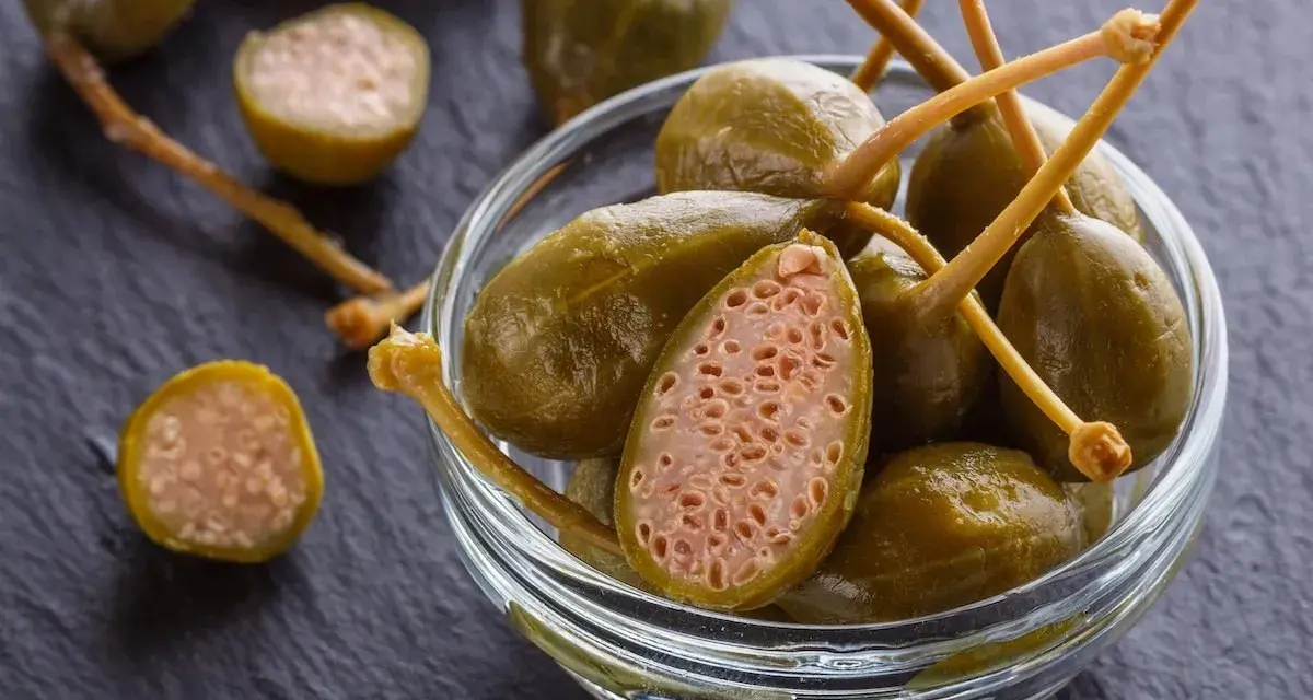 Cucunci sotto sale in una ciotola di vetro, alcuni tagliati a metà rivelano la loro polpa interna.