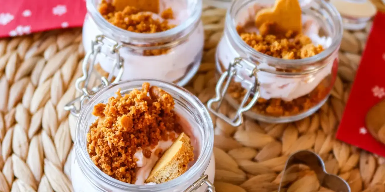 Söta små glasburkar med rosa kräm, smulad kaka och hjärtformade kex. Ett perfekt mjukglass recept utan glassmaskin för alla hjärtans dag.