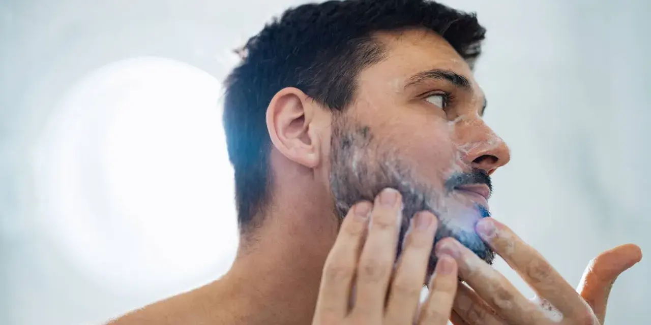 Hombre aplicándose espuma para quitarse la barba.