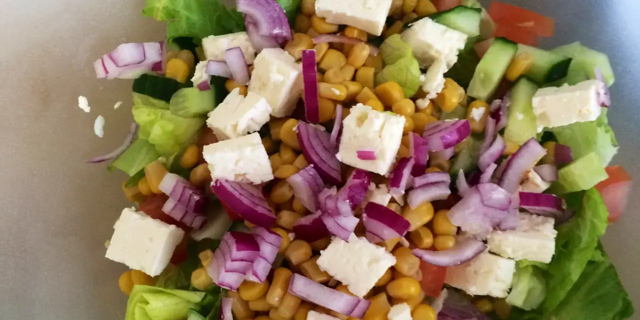 En fräsch sallad med sallad, majs, fetaost, rödlök och gurka. Perfekt för ett lätt och näringsrikt deffa kostschema.