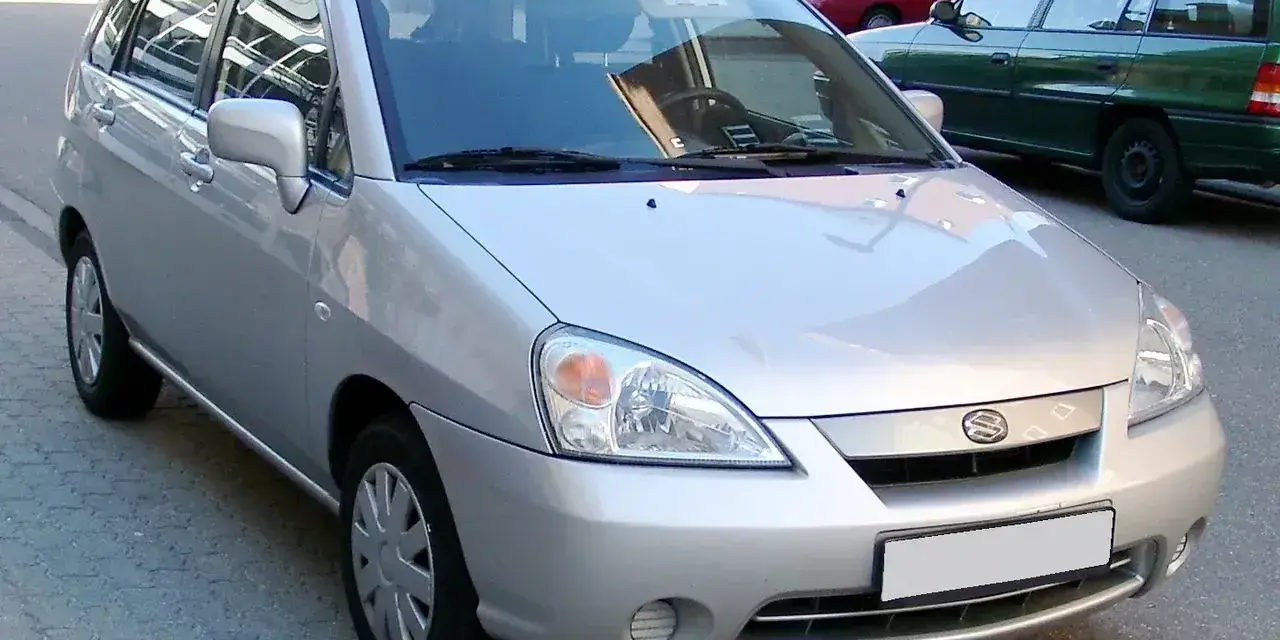 Srebrne Suzuki Liana stoi na ulicy.