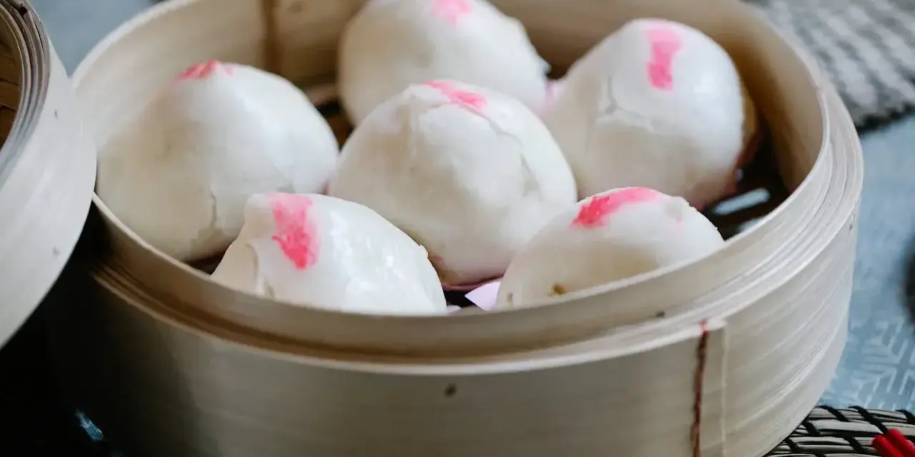 Pierożki baozi w bambusowym parowniku, gotowe do podania.