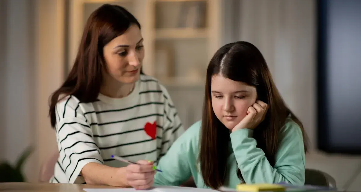 Mama tłumaczy córce, jak działa edukacja domowa. Dziewczynka zamyślona, opiera głowę na dłoni.