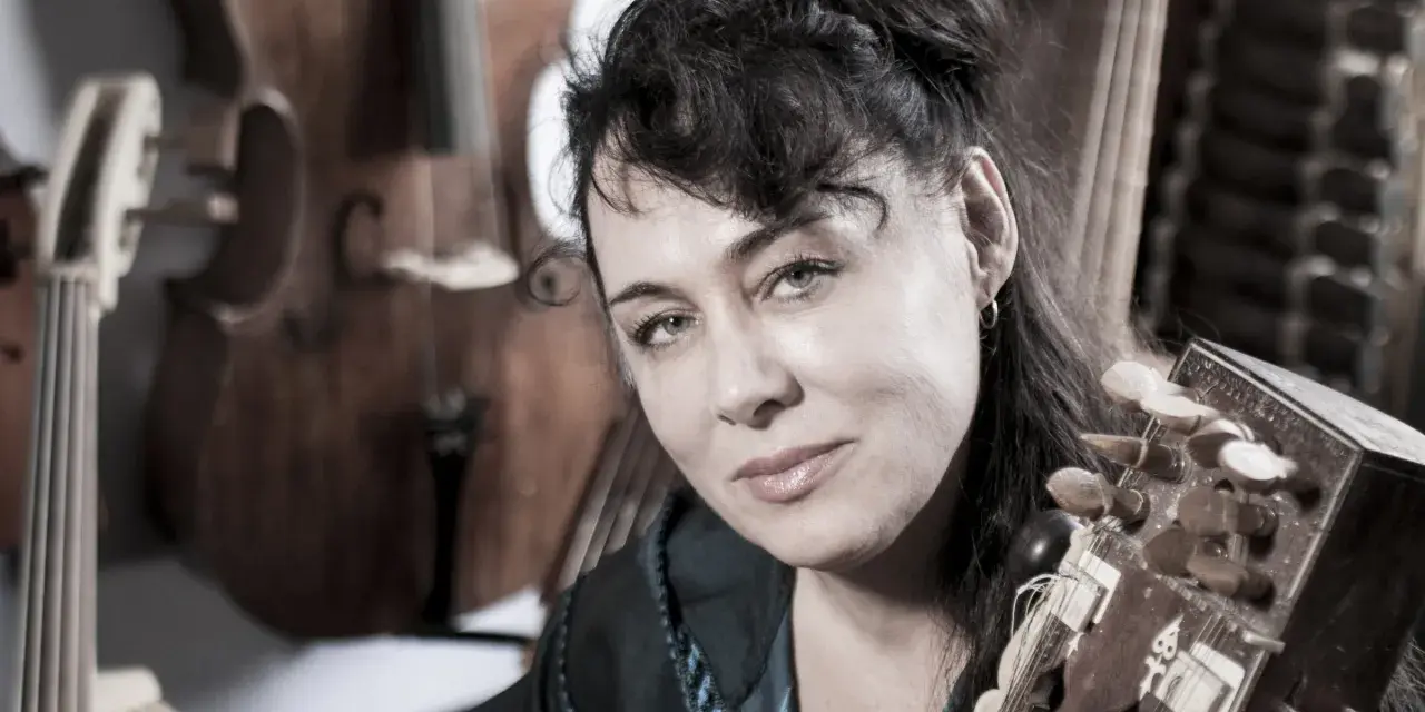 Maria Pomianowska z fidelą i instrumentami smyczkowymi w tle.