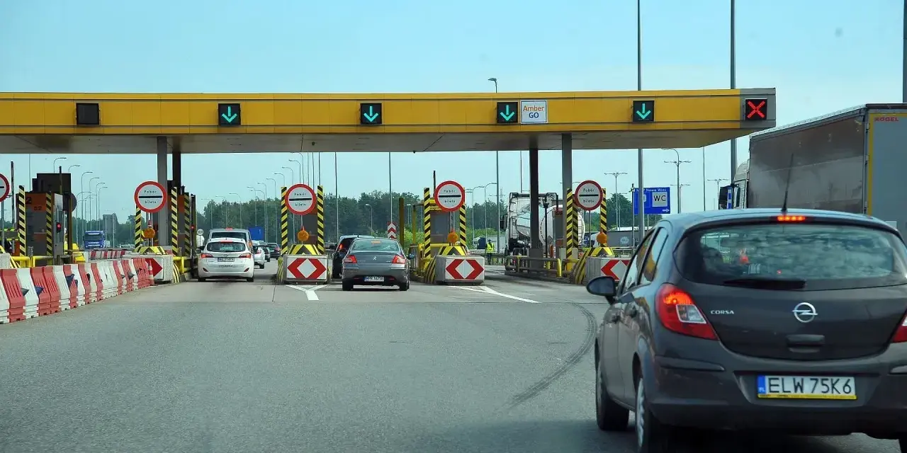 Bramki autostrady A1 z samochodami zbliżającymi się do punktu poboru opłat.