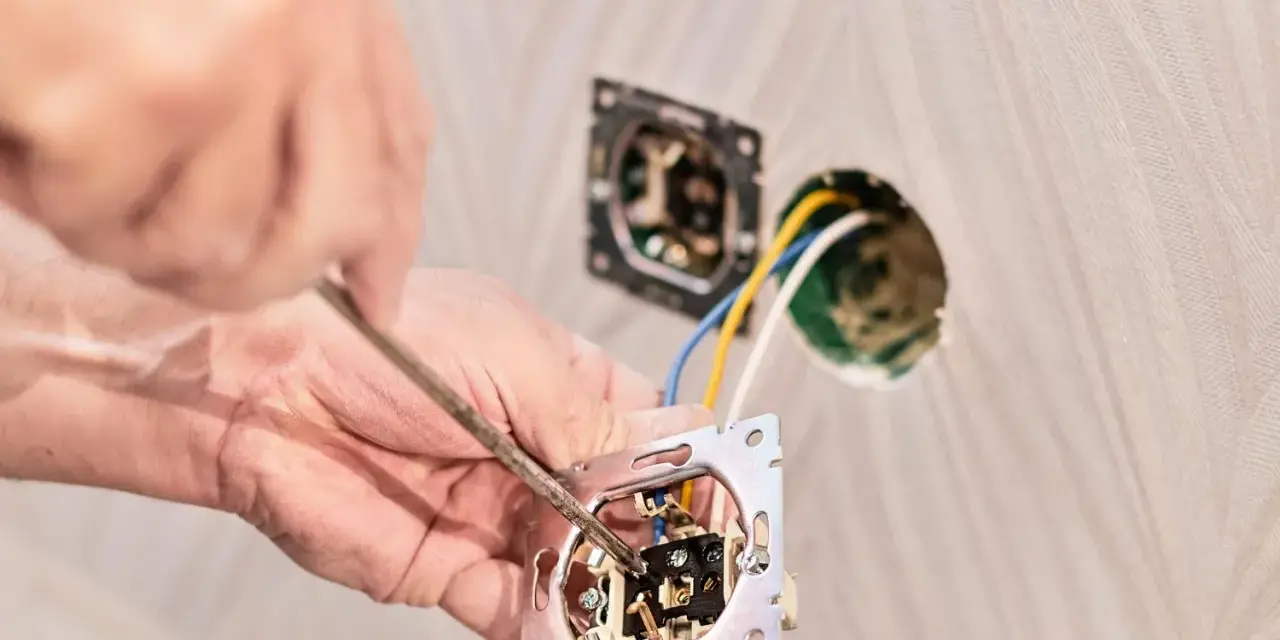 Instalator podłącza podwójny włącznik światła, pokazując jak podłączyć włącznik światła podwójny trzy przewody.