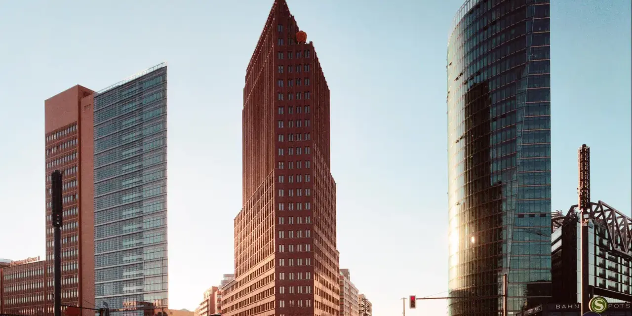 Moderne Hochhäuser am Potsdamer Platz in Berlin, darunter der spitze roter Backsteinbau, der an den schnellsten Fahrstuhl Berlins erinnert.