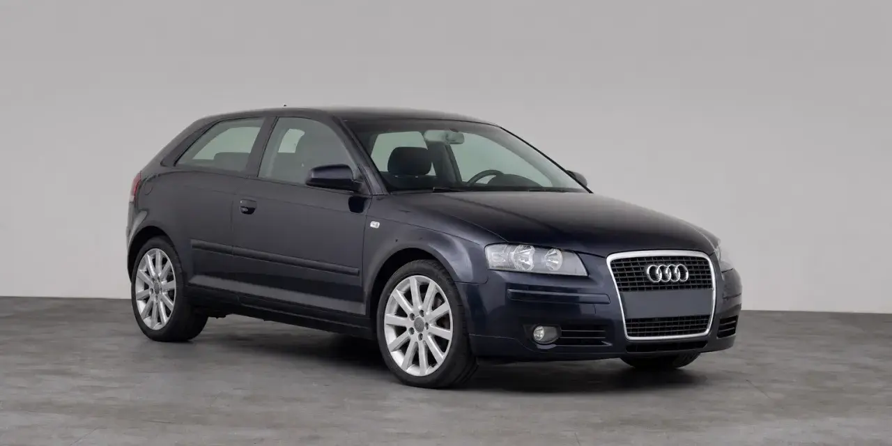 Dunkelblauer Audi A3 1.9 TDI Dreitürer steht auf grauem Boden vor hellem Hintergrund.