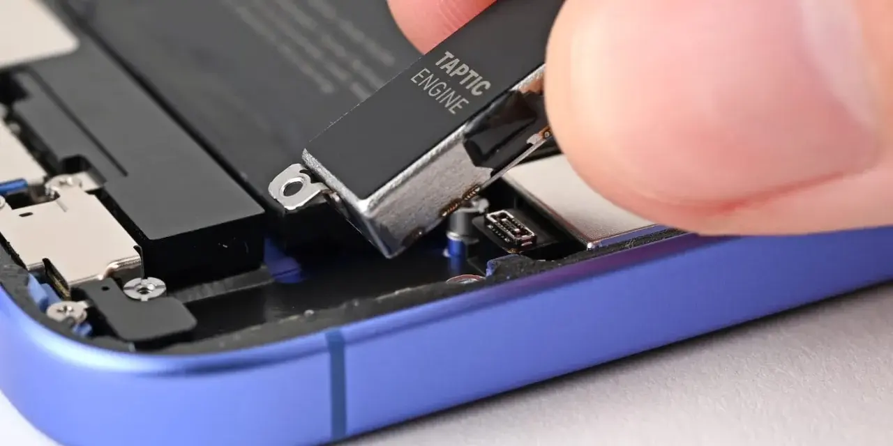 Dłoń wyjmuje moduł Taptic Engine z wnętrza telefonu, element odpowiedzialny za zaawansowane wibracje i 3D Touch.