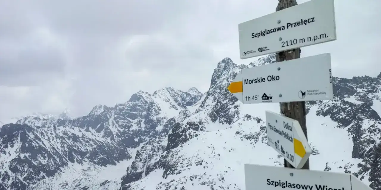 Szpiglasowy Wierch od Morskiego Oka. Znak szlaku w zimowych Tatrach wskazuje drogę na szczyt.