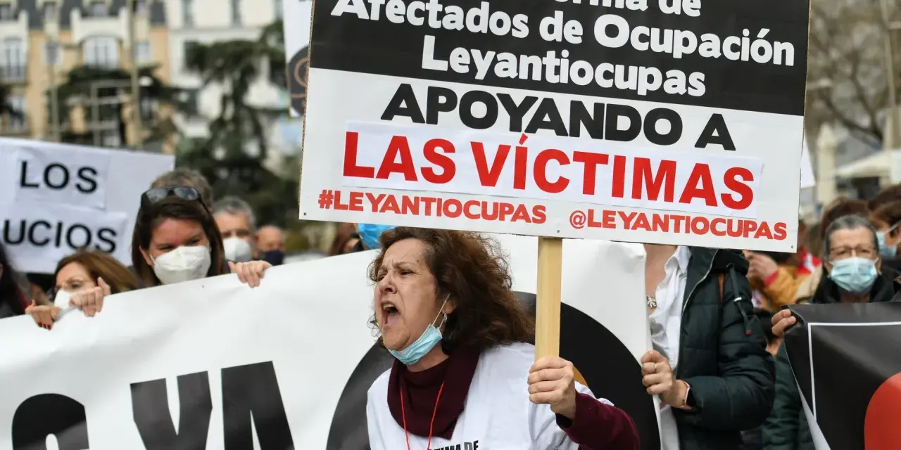 Manifestantes protestan contra la ocupación de vivienda habitual. Una mujer grita, portando un cartel que apoya a las víctimas de #Leyantiocupas.