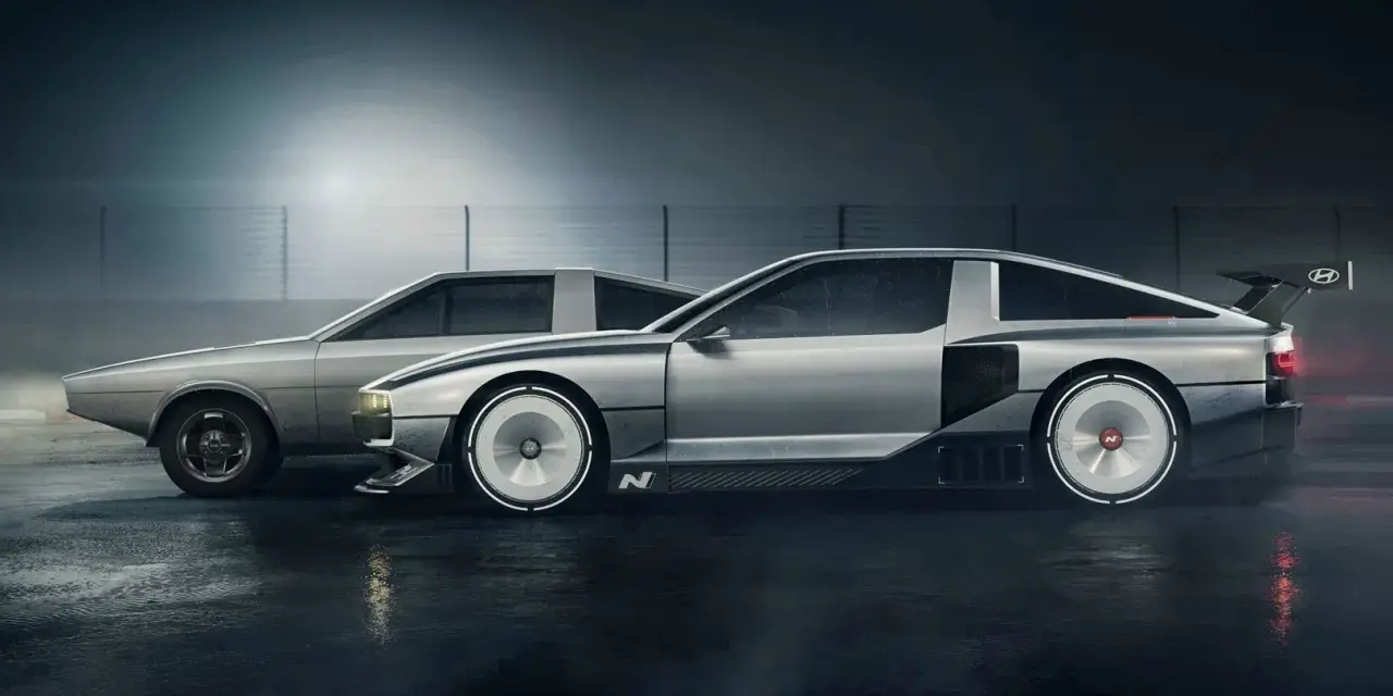 Dwa samochody Hyundai N Vision 74 stoją obok siebie na mokrej nawierzchni. Jeden jest bardziej klasyczny, drugi futurystyczny.