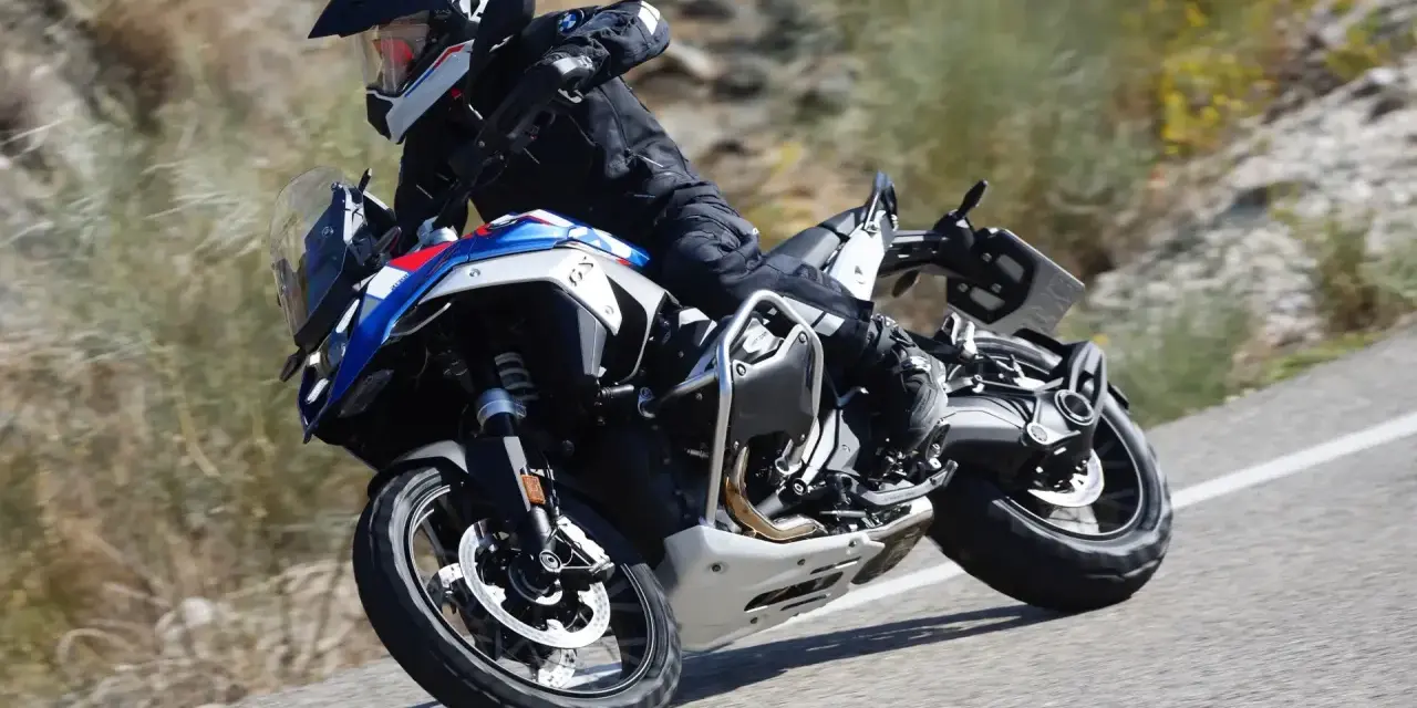 Motociclista in sella a una BMW GS 1300, che affronta una curva su strada sterrata, sfiorando la velocità massima.