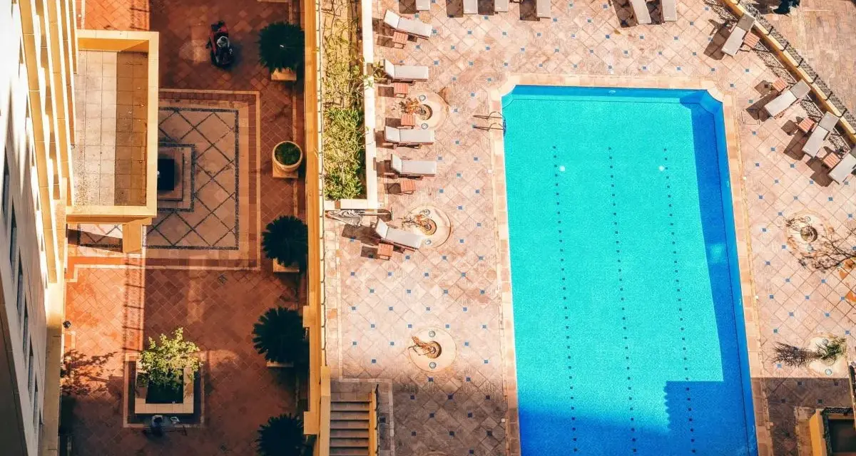 Widok z góry na basen i dziedziniec hotelowy. Idealne miejsce na wakacje all inclusive soft.