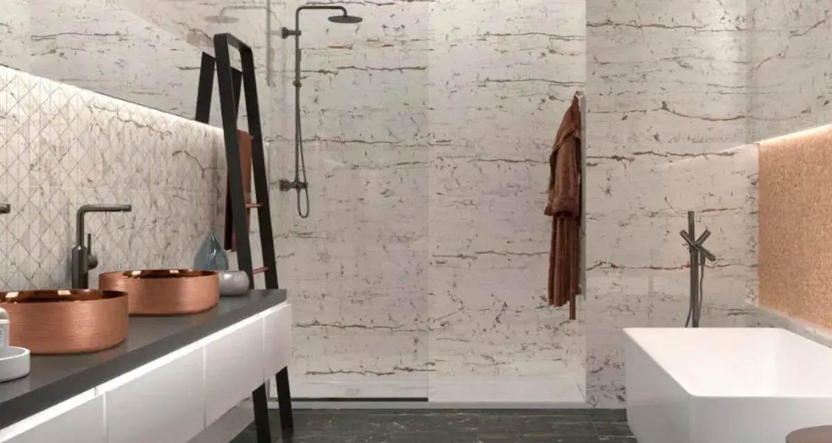 Salle de bain moderne avec murs texturés rappelant la pierre de Bourgogne, double vasque en cuivre, baignoire îlot et douche à l'italienne.