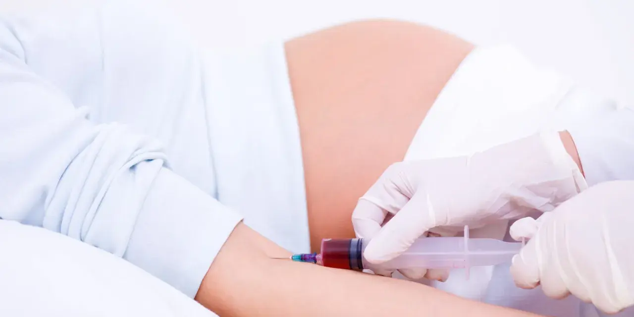 Pobieranie krwi do badań w 15 tygodniu ciąży. Brzuch ciężarnej i ręka z igłą strzykawki.