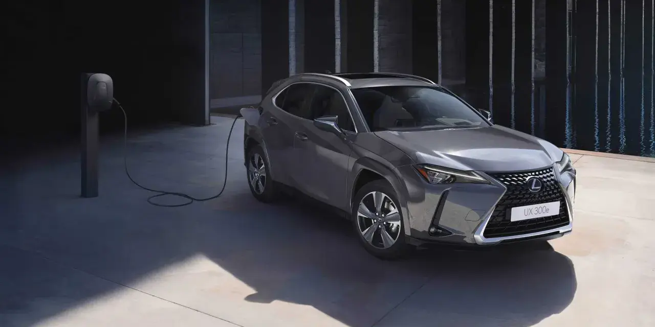 Szary Lexus UX 300e podłączony do ładowarki, gotowy na ekologiczną podróż.