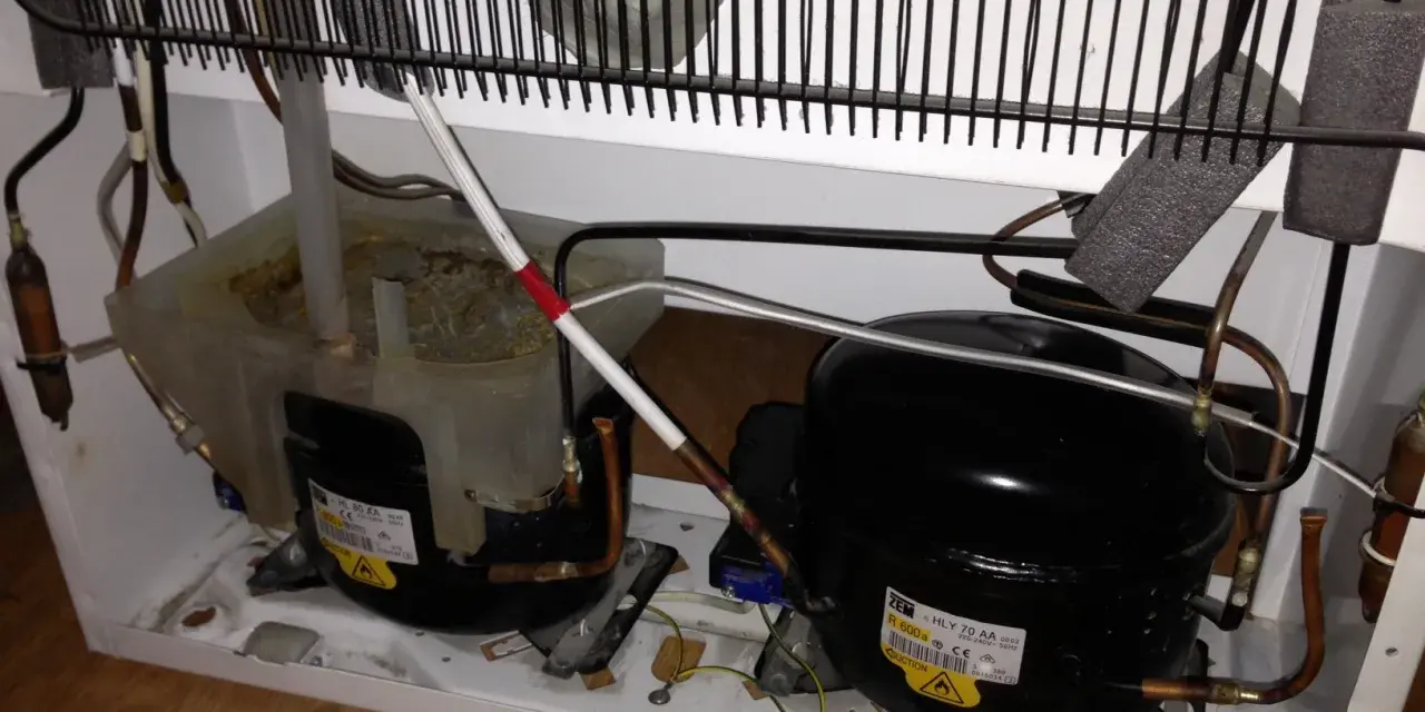 Kylskåpets kompressorer och kondensor. Det låter som en borr när kylskåpet går.