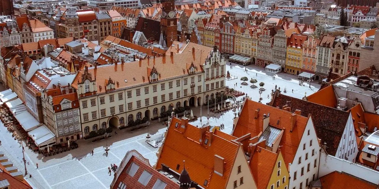 Widok z góry na Rynek we Wrocławiu z kolorowymi kamienicami i ratuszem.