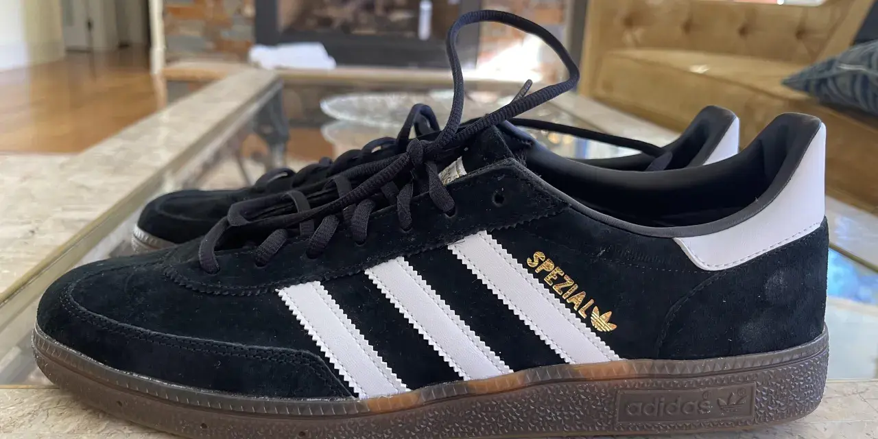 Czarne buty Adidas Spezial z białymi paskami i złotym napisem. Zwróć uwagę na detale, jak rozpoznać oryginalne buty Adidas.
