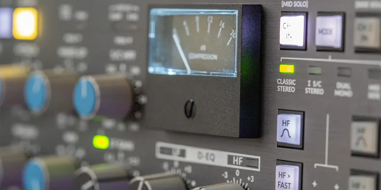 Regler und VU-Meter eines Mischpults, das die analoge Welt der Musikproduktion zeigt.