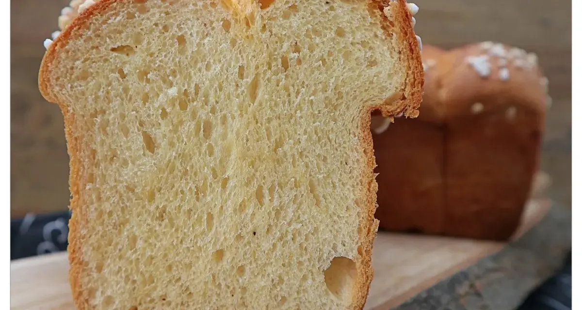 Schnitt von einem goldbraunen Brioche-Brot, perfekt für Lievito Madre Rezepte. Die weiche Krume mit kleinen Luftlöchern und die süße Kruste laden zum Genuss ein.