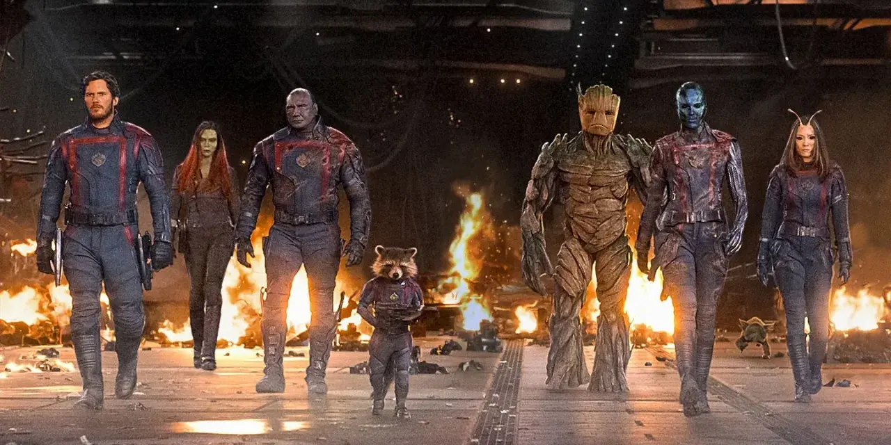 Strażnicy Galaktyki: Volume 3 obsada – Star-Lord, Gamora, Drax, Rocket, Groot, Nebula i Mantis idą przez płonące ruiny.