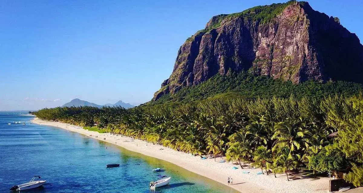 Mauritius pogoda sierpień: rajska plaża z palmami, turkusowa woda i majestatyczna góra Le Morne. Idealne warunki na wakacje.