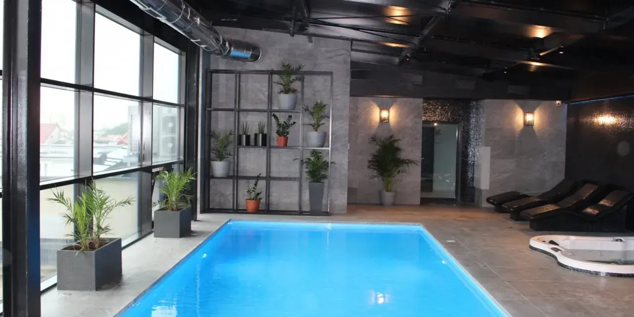 Nowoczesny hotel spa Białystok z basenem, jacuzzi i leżakami. Duże okna z widokiem na miasto.