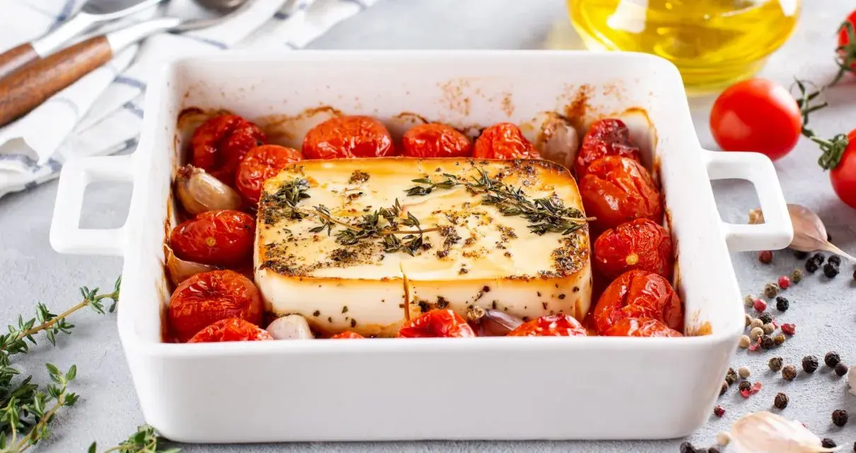 Pieczeni ser feta z pomidorkami koktajlowymi i czosnkiem, idealne dania na imprezę na ciepło.