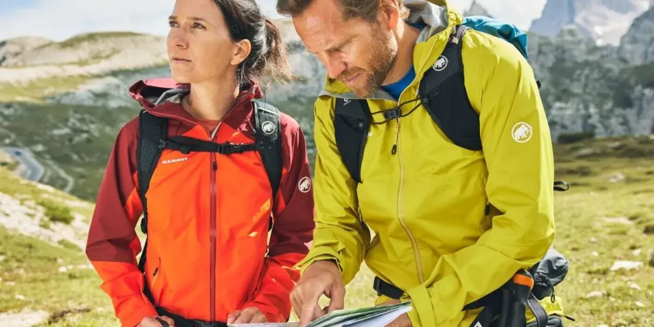 Wanderer prüfen die Route. Ihre wasserdichten Jacken schützen sie vor dem Wetter.