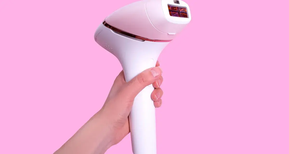 Biały depilator laserowy w dłoni. Dowiedz się, jak używać depilatora laserowego dla gładkiej skóry.