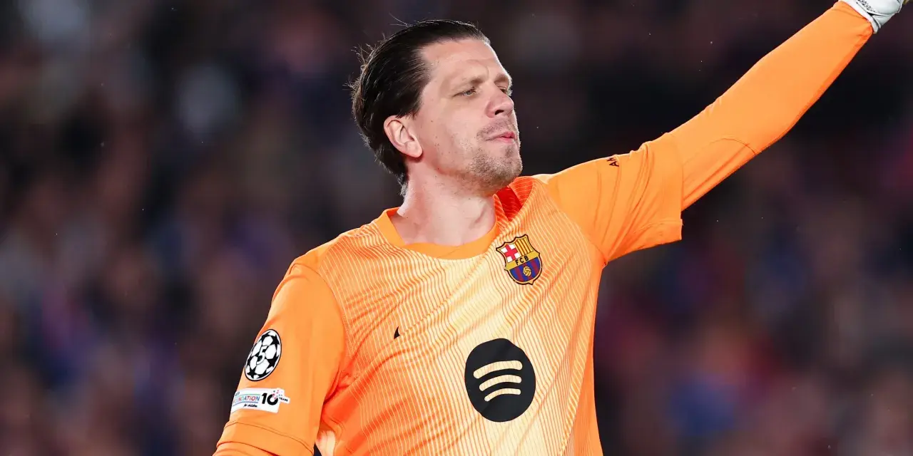 Wojciech Szczęsny w pomarańczowej koszulce bramkarskiej FC Barcelony, z podniesioną ręką, gotowy do obrony.