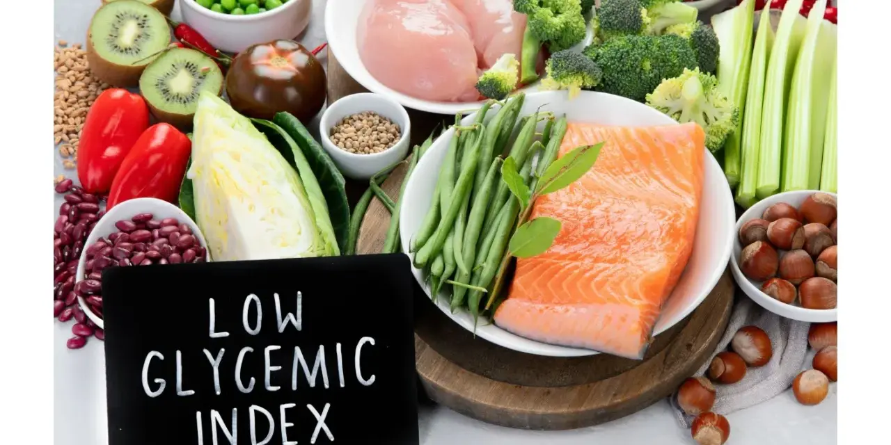 Łosoś, kurczak, warzywa, owoce i orzechy na tle tabliczki z napisem "Low Glycemic Index".